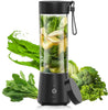 Black portable blender with green vegetables inside, surrounded by more vegetables on a white background