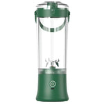 A portable electric blender with a dark green base and upper collar, a clear cylindrical container, and a silver blade assembly inside, shown on a plain white background.